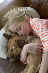 niña durmiendo con su perro en casa unifamiliar